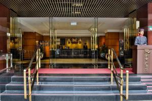 a lobby of a hotel with stairs and a bar at Hotel Riverview Taipei in Taipei