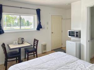 a bedroom with a bed and a table and a microwave at Sunny Motel Port Elgin in Port Elgin