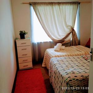 1 dormitorio con 2 camas, vestidor y ventana en Room in BB - Zagorskis Bed and breakfast close to the beach and commodities, en Ciudad del Cabo