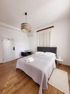 a white bedroom with a large bed with a white blanket at Apartments Miljas 2 in Dubrovnik