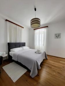 a white bedroom with a large bed and a large window at Apartments Miljas 2 in Dubrovnik