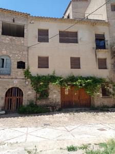 レトゥルにあるCasa Rural Juan, el Zapaの窓とドアが組み込まれた古い石造りの建物