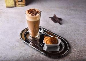 a tray with a cup of coffee and a pastry at Holiday Inn Al Khobar - Corniche, an IHG Hotel in Al Khobar