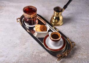 a tray with two cups of coffee and a plate of food at Holiday Inn Al Khobar - Corniche, an IHG Hotel in Al Khobar