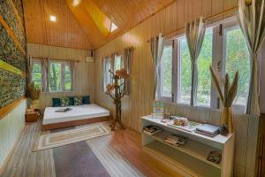 a room with a bed and a table and windows at SaffronStays The Elements in Kulu