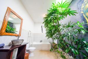 uma casa de banho com uma banheira, um WC e plantas em Villa CRIS - Heart of LEGIAN 3 Bedrooms, 3 Bathrooms em Legian