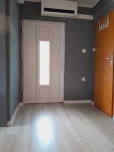 Habitación vacía con puerta blanca y suelo de madera. en Kuća za odmor 204 jezero Šoderica en Legrad