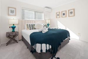 a bedroom with a bed with a blue blanket on it at Soulshine Beachside Penthouse in Surf Beach