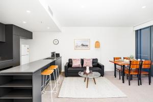a kitchen and living room with a couch and a table at Brandnew Spacious and Stunning 1bed Apartment in Brisbane