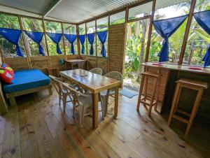 a room with a table and chairs in a house at Arboura Eco Cabins in Uvita