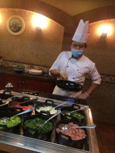 a chef standing in a kitchen preparing food at Holiday Inn Al Khobar, an IHG Hotel in Al Khobar