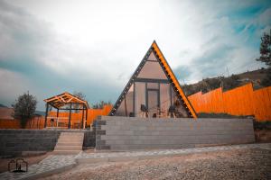 een klein huis met een oranje hek en een trap bij Triangle House in Dilidzjan