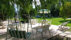 un grupo de sillas y mesas en un parque en Las Camelias Apart en Chascomús