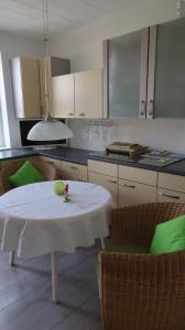 eine Küche mit einem Tisch und einem weißen Tischtuch darauf in der Unterkunft Happy 1 in Quierschied