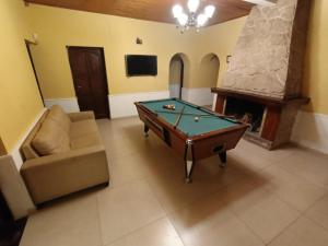 sala de estar con mesa de billar y chimenea en Casa en chacras de Coria en Ciudad Lujan de Cuyo