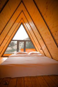 uma cama num quarto com uma grande janela em Triangle House em Dilijan