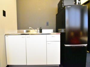 a kitchen with a sink and a refrigerator at The Garden Place Hiroshima - Vacation STAY 89276v in Hiroshima