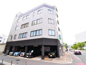 a white building with cars parked in front of it at The Garden Place Hiroshima - Vacation STAY 89276v in Hiroshima