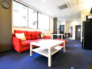 a living room with a red couch and a table at The Garden Place Hiroshima - Vacation STAY 89276v in Hiroshima