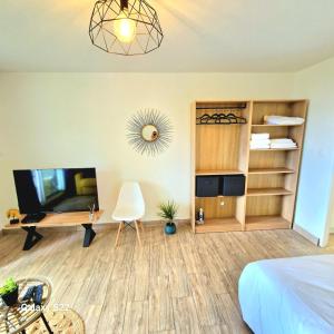 a bedroom with a bed and a desk and a television at Studio P'ti Boucan in Saint-Gilles les Bains