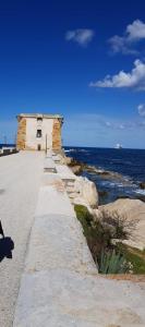 a walkway next to the ocean with a building at casa ANNA in Trapani
