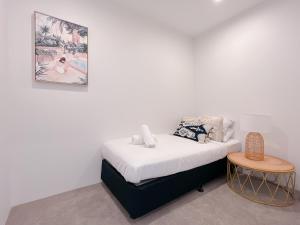 a white room with a bed and a table at Brand New Riverside Designer 2BD apartment at West End in Brisbane