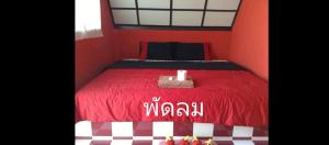 - une chambre rouge avec un lit doté d'un couvre-lit rouge dans l'établissement เขาค้อ อันนาอิม รีสอร์ท, à Ban Thung Samoe