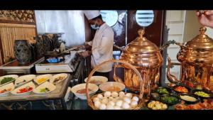 un chef de pie en una cocina preparando comida en Golden Tulip Al Khobar en Al Khobar