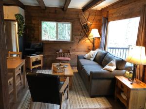 a living room with a couch and a table at 4 Mile Creek Cabin (Creekside) in Nelson