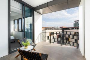布里斯班Stylish 1BD Apt with Ideal Location in Southbank的建筑物上的带桌椅的阳台