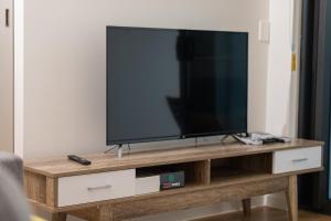 a flat screen tv sitting on top of a wooden entertainment center at Stylish 1BD Apt with Ideal Location in Southbank in Brisbane