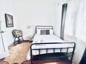 a small bedroom with a bed and a window at Margaret House ~ Circa 1930 in Coffs Harbour