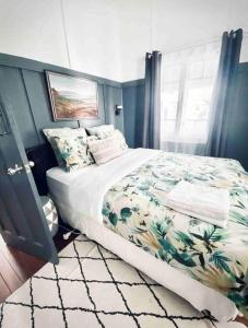 um quarto com uma cama com colcha floral em Margaret House ~ Circa 1930 em Coffs Harbour