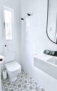a white bathroom with a toilet and a sink at Margaret House ~ Circa 1930 in Coffs Harbour