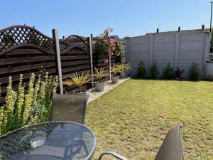 a garden with a table and a fence with plants at Homely Hideout near Heathrow, Windsor minutes from M4 in Slough