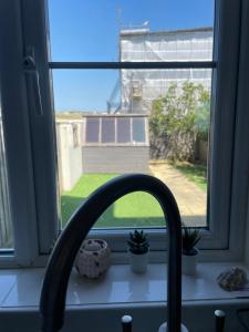 a kitchen window with a sink and a faucet at Sea views in Southwell
