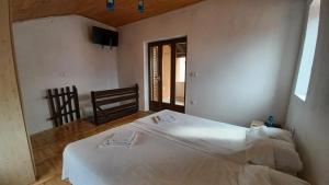 ein Schlafzimmer mit einem weißen Bett und einem Stuhl in der Unterkunft Apartmani Krapanj in Krapanj