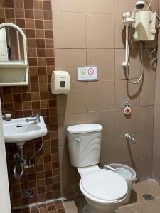 a bathroom with a toilet and a sink at The Sonly Suites in General Santos