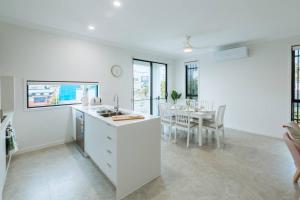 a white kitchen and dining room with a table at Spacious Modern and Cozy 3BD Townhouse at Great Location in Gold Coast