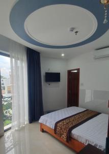 een slaapkamer met een bed en een flatscreen-tv bij LUCKY HOTEL in Vung Tau