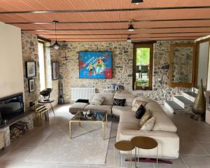 a living room with a couch and a stone wall at Casale del Pozzo-Villa with pool - Fosdinovo in the borgo of Pulica in Tendola