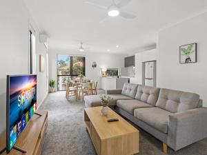 a living room with a couch and a tv at Newly Furnished Spacious 3BR Townhouse at GC in Gold Coast