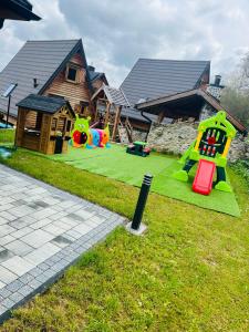 a playground with several play equipment in front of a house at Santa Angela Solina Resort & SPA in Solina