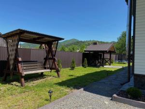 a yard with a bench and a gazebo at Mountain Residence in Tukhlya