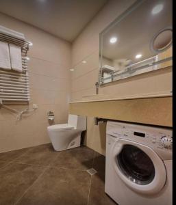 een badkamer met een wasmachine en een toilet bij Happy Days in Dreamland Oasis in Chakvi