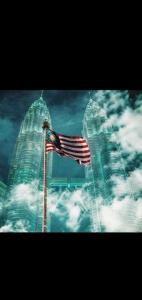 an american flag flying in front of two tall buildings at Best dreams KLtaragon residence in Kuala Lumpur