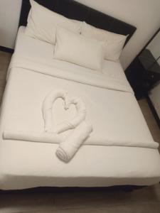 two towels in the shape of a heart on a bed at Best dreams KLtaragon residence in Kuala Lumpur