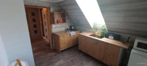 uma pequena cozinha com um lavatório e uma janela em Apartmán Dobrná 