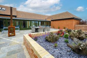 オールドバラにあるAlde Bay Farm - Barn Owl Sanctuaryの花が咲くパティオ(テーブル、椅子付)