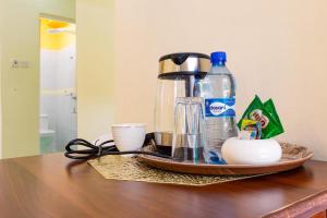 a tray with a coffee maker and a bottle on a table at Marrkson Suites in Nairobi